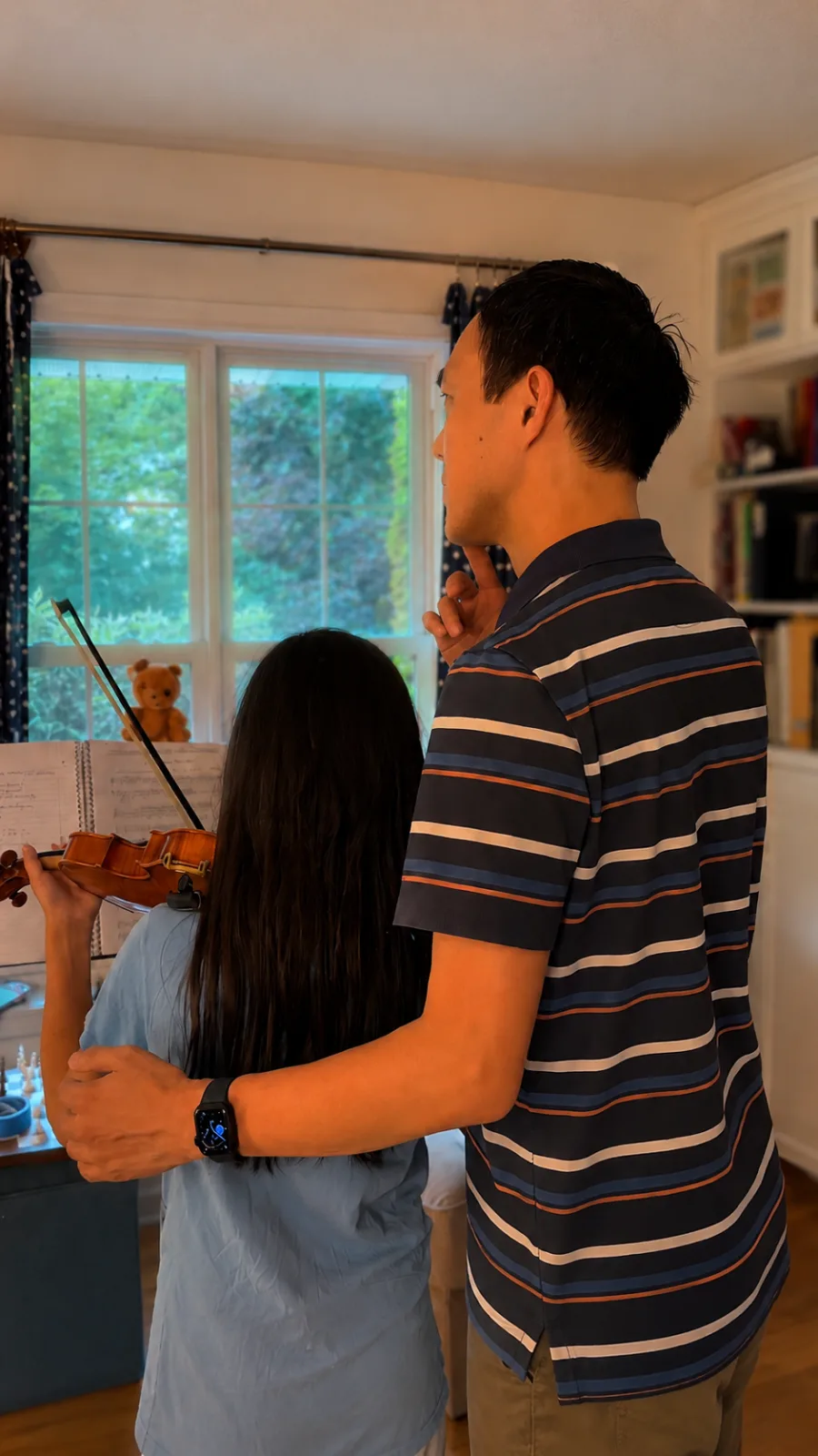 Ben Chan supporting a young violin learner between lessons